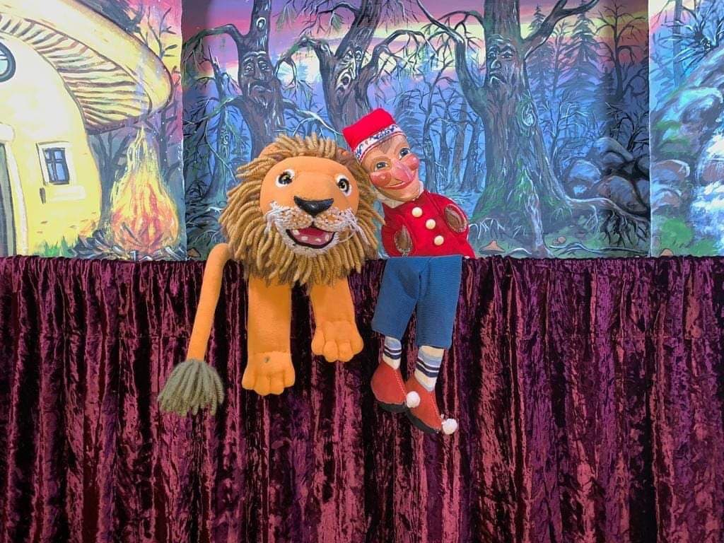 Kasper und der Löwe vor der Zauberwald-Kulisse